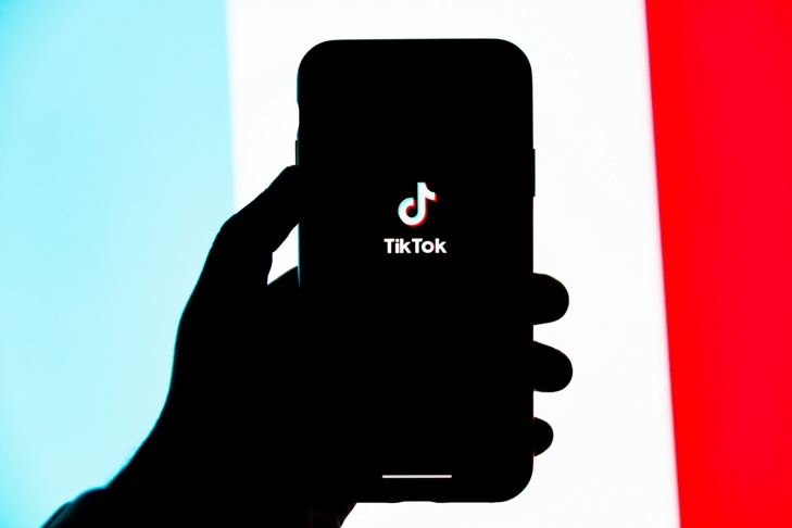 silhouet van een hand met een smartphone tegen een kleurrijke achtergrond
