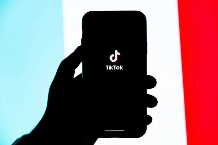 renkli arka plan üstünde akıllı telefon tutan bir el silüeti