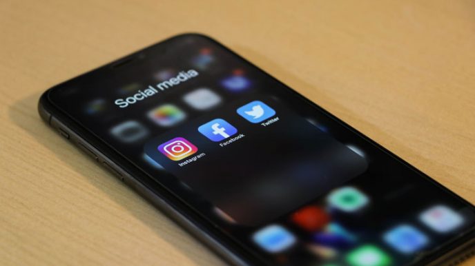 En smartphone med apparna Instagram, Facebook and Twitter markerade.  Sociala medier är en viktig del av din marknadsföringsstrategi för innehåll under säsongen fylld av erbjudanden.